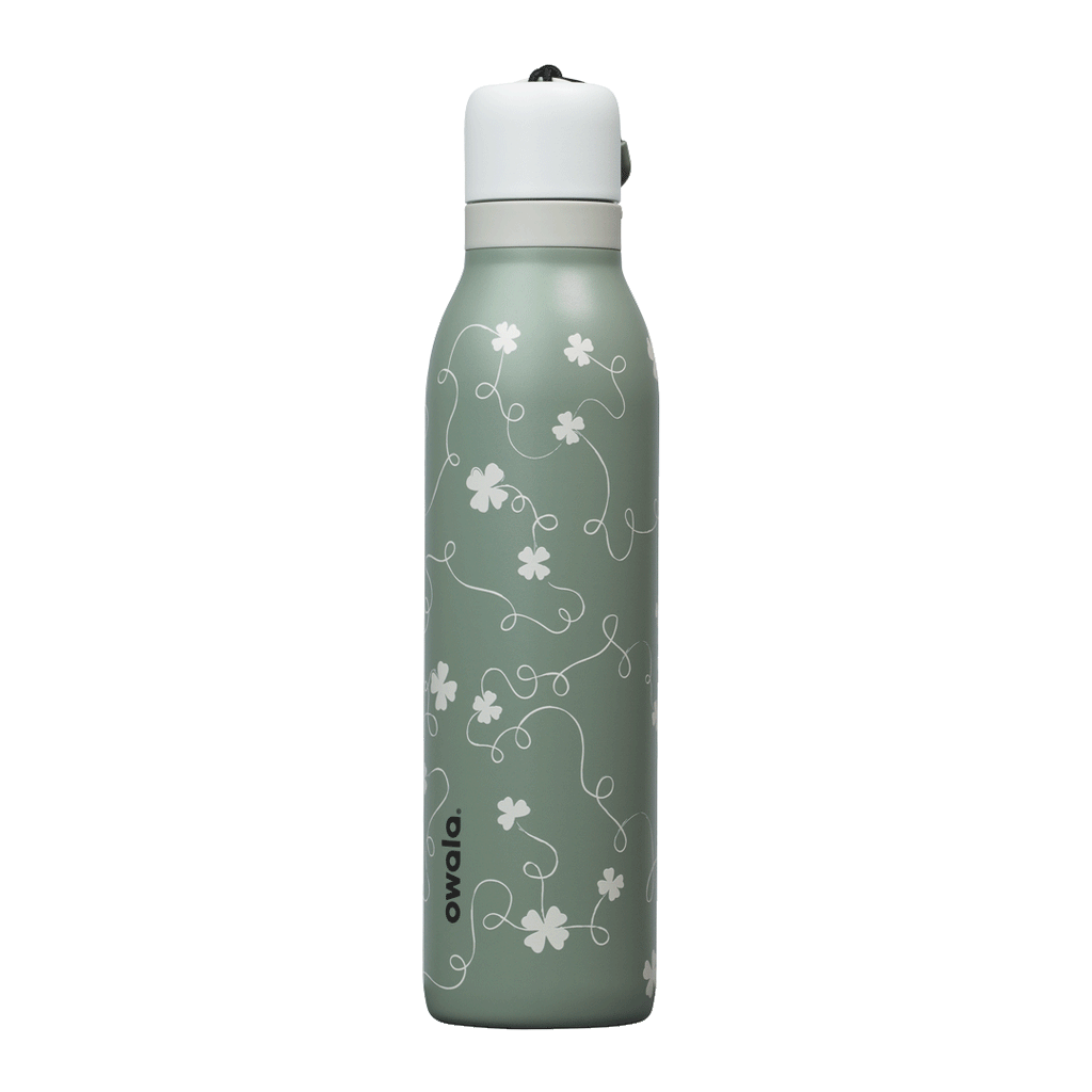 Owala FreeSip Twist 24oz in Clover Achiever, close-up of the sage green body with white clover and vine pattern and the white twist cap with sage carry string and dark carry string grip